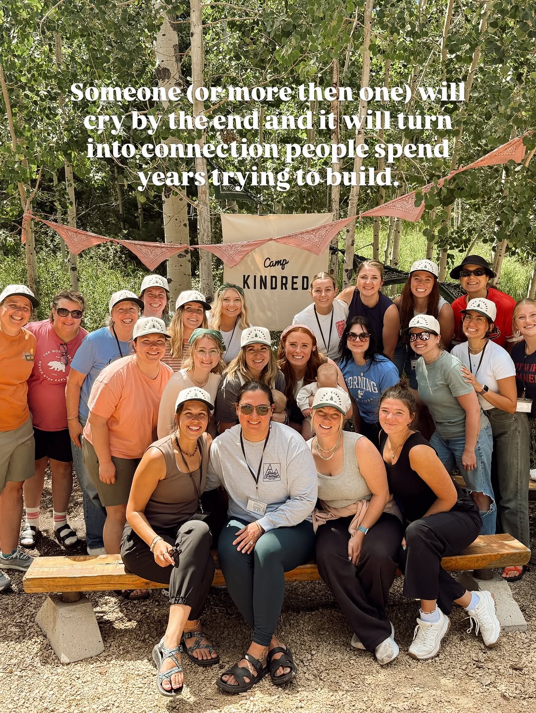 Camp Kindred campers gathered beneath a banner in the mountains